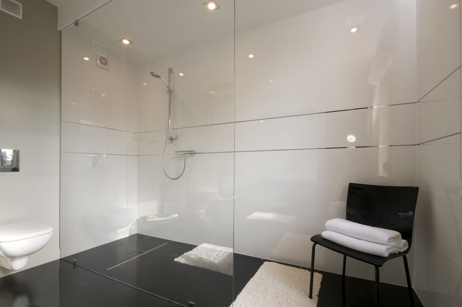 16 białe płytki czarne płytki krzesło kabina prysznicowa